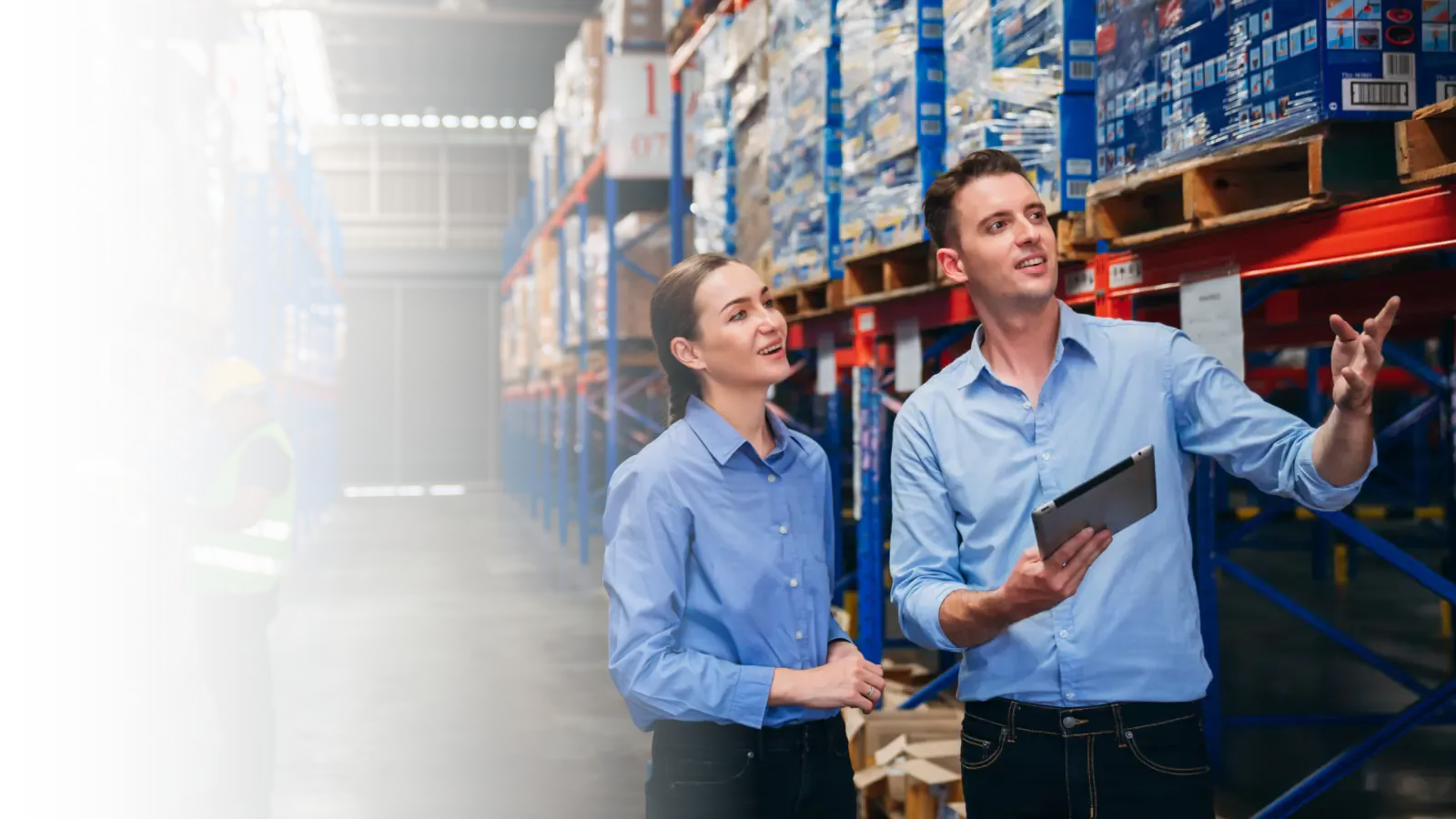 Warehouse team reviewing live operations data on a tablet, with ERP, WMS and data platforms represented across the facility